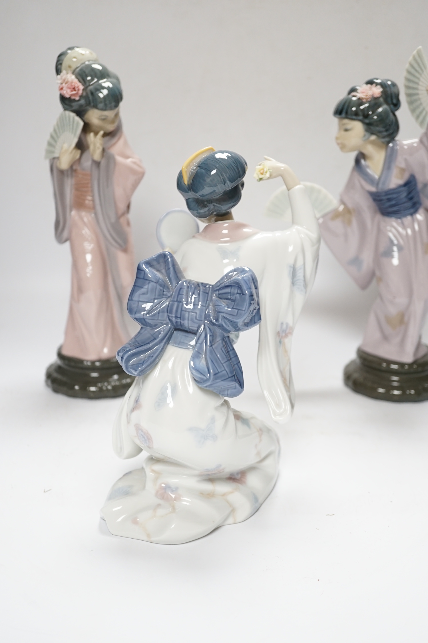 Three Lladro figures, Mirror Mirror, and two Japanese Geisha girls holding fans, (one boxed) tallest 29cm high